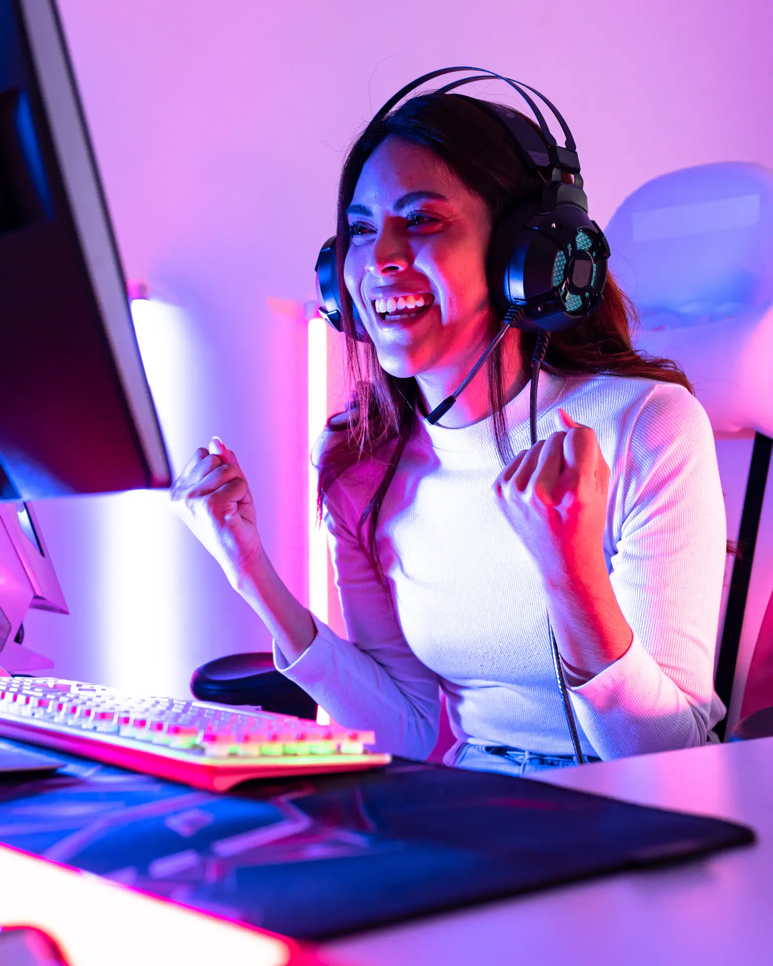 Person working at a glowing multi-screen setup